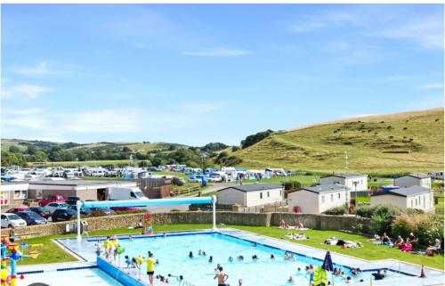 a large swimming pool with people in a park at Ardmachree in Burton Bradstock