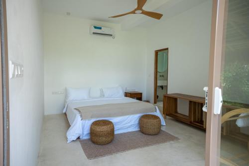 a bedroom with a bed and a ceiling fan at Villa Vera in Ahangama