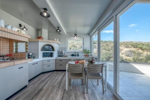 a kitchen with white cabinets and a table with chairs at Casa Elea in Kissamos