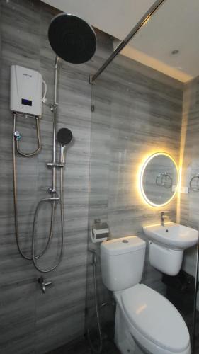 a bathroom with a shower and a toilet and a sink at Ola De Baler Hotel in Baler