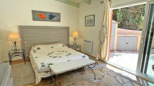 une chambre avec un lit et une grande fenêtre dans l'établissement Bastide Coriolan, à Préconil