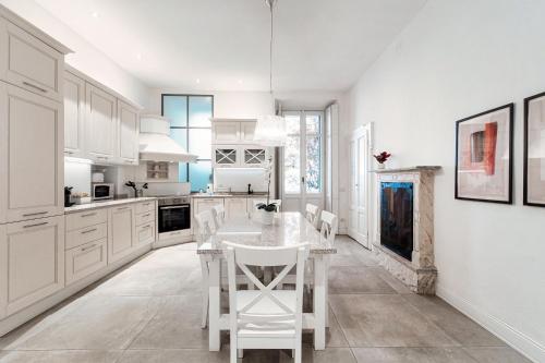 een keuken met witte kasten en een tafel en stoelen bij Cedro Apartment by Quokka 360 - designer flat in Como in Como