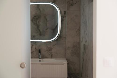 a bathroom with a sink and a mirror on the wall at Natural Blue Suites-Canal d'Amour Retreat in Sidari