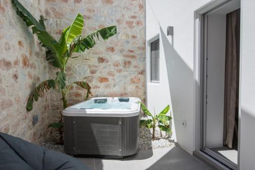 a bathroom with a bath tub next to a plant at Blue Mare Villas in Naousa