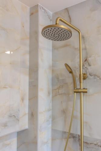 a shower with a gold shower head in a bathroom at Casa Elea in Kissamos