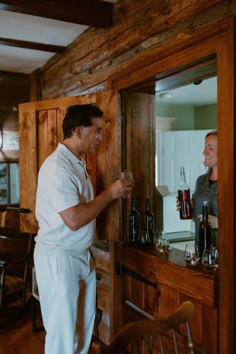 a man standing at a bar holding a glass at Events and Concierge, 6BR Heated Pool Near Wineries in Hume
