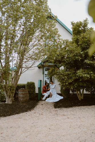 a bride and groom sitting on a bench next to a building at Events and Concierge, 6BR Heated Pool Near Wineries in Hume