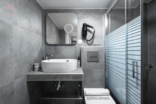 łazienka z umywalką i lustrem w obiekcie Modeco, Nilie Hospitality MGMT w Salonikach