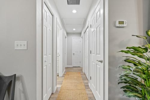 a hallway with white doors and a rug at Dunnellon Dream. Pool, Fire Pit and Outdoor Bar in Dunnellon