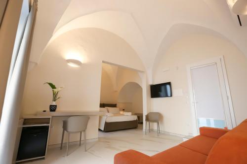 a living room with a couch and a bed at Le Due Dimore in Collepasso