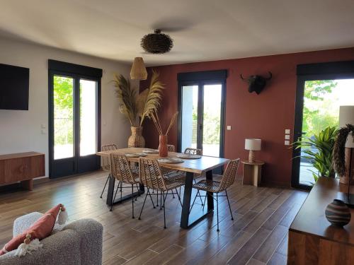 a living room with a dining room table and chairs at La Maison Zanzibar in Lavilletertre