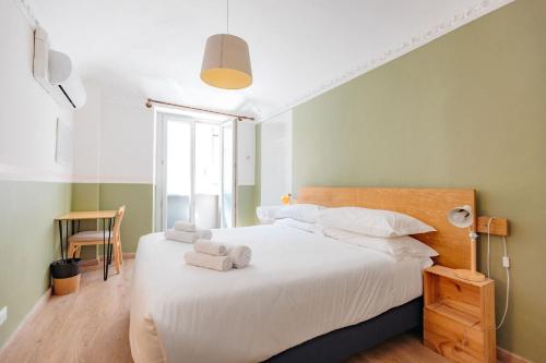 a bedroom with a large white bed with towels on it at Tomato Urban Retreat in Turin
