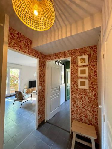 un couloir avec des murs rouges et un plafond avec un lustre dans l'établissement Le Loft de Genas - La Cabane, à Genas