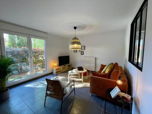 salon z kanapą i stołem w obiekcie Le Loft de Genas - La Cabane w mieście Genas