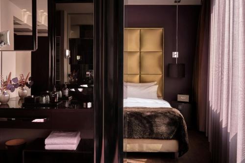 a bedroom with a bed and a mirror at Roomers Frankfurt Central, Autograph Collection in Frankfurt/Main