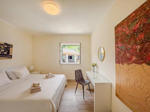 a bedroom with two beds and a desk and a window at Villa Olive retreat in Krilo