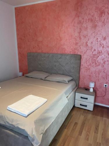 a bedroom with a bed and a red wall at Villa Nilić in Bar