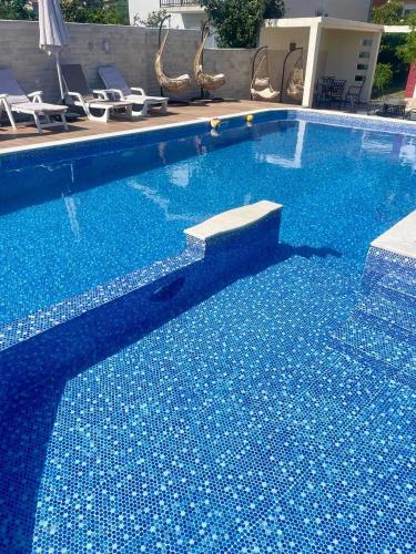 a large blue swimming pool with blue tiles on it at Villa Nilić in Bar
