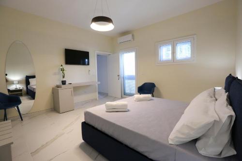 a bedroom with a large bed and a room with a desk at Le Due Dimore in Collepasso