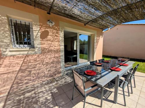 Une table à manger et des chaises sont disponibles sur la terrasse. dans l'établissement Mont Ventoux 5-person villa with spa, jacuzzi in Provence, à Mazan