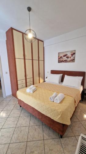 a bedroom with a large bed with two towels on it at Nicole House in Ayia Evfimia