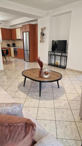a living room with a table and a kitchen at Nicole House in Ayia Evfimia