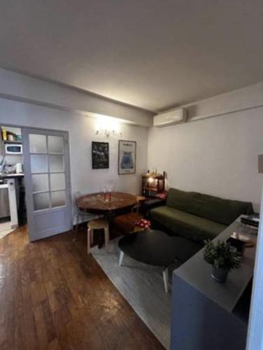 un salon avec un canapé vert et une table dans l'établissement The Building Canebière, à Marseille