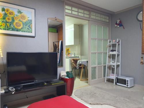 a living room with a large flat screen tv at Quiet Accommodation Next to Geumho River in Daegu