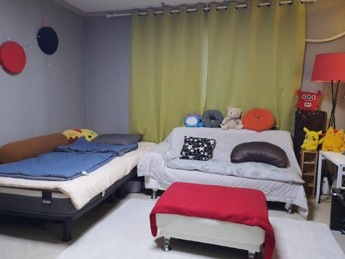 a bedroom with two beds and a table with a chair at Quiet Accommodation Next to Geumho River in Daegu