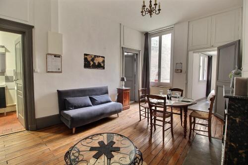 un salon avec un canapé et une table dans l'établissement Le Logis d'Henri by Primo Conciergerie, à Bourges