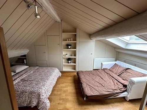 une chambre avec deux lits dans un grenier dans l'établissement Loft Duplex 33 Career, à Nancy