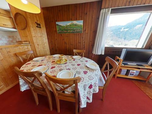 une salle à manger avec une table avec des chaises et une télévision dans l'établissement Appt 3 pièces 6 pers avec cheminée et navette proche Le Grand-Bornand - FR-1-241-47, au Grand-Bornand