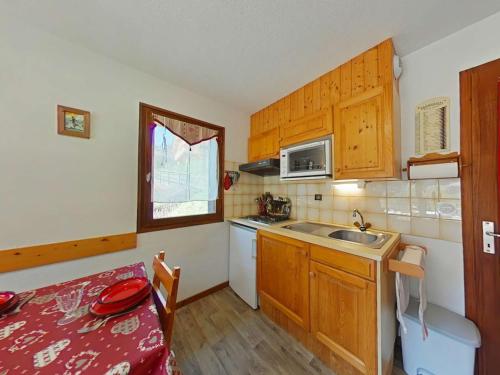 une petite cuisine avec une table et un évier dans l'établissement Appt 2 pièces, 6 couchages, 900m télécabine, parking - FR-1-241-52, au Grand-Bornand