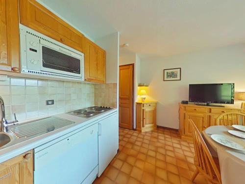 une cuisine avec un évier et une cuisinière four supérieur dans l'établissement Appartement cosy 5 couchages avec balcon, navette au pied, garage et ménage inclus - Le Grand-Bornand - FR-1-241-198, au Grand-Bornand