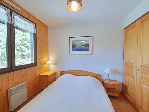 une chambre avec un lit blanc et une fenêtre dans l'établissement Appartement cosy 5 couchages avec balcon, navette au pied, garage et ménage inclus - Le Grand-Bornand - FR-1-241-198, au Grand-Bornand