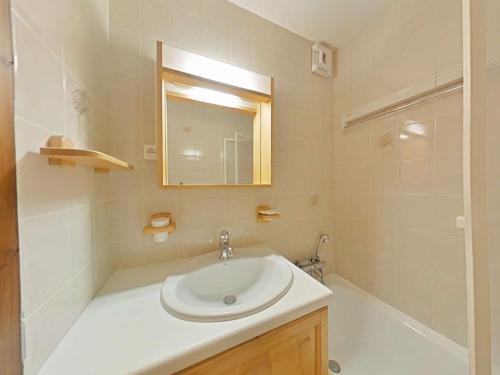 une salle de bain avec un lavabo, un miroir et une baignoire dans l'établissement Appartement cosy 5 couchages avec balcon, navette au pied, garage et ménage inclus - Le Grand-Bornand - FR-1-241-198, au Grand-Bornand
