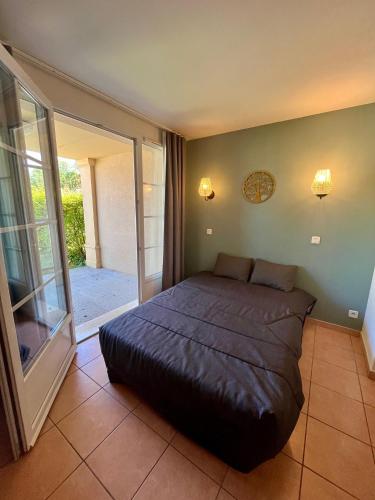 une chambre avec un lit et une porte coulissante en verre dans l'établissement Le SPOT Piscine chauffée & Fun, à Monflanquin