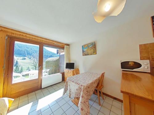Cette petite chambre dispose d'une table et d'une fenêtre. dans l'établissement Studio cosy avec terrasse sud, proche navettes, Le Grand-Bornand - FR-1-241-51, au Grand-Bornand