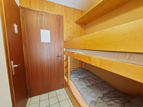 Cette petite chambre comprend 2 lits superposés et une porte. dans l'établissement Studio cosy avec terrasse sud, proche navettes, Le Grand-Bornand - FR-1-241-51, au Grand-Bornand