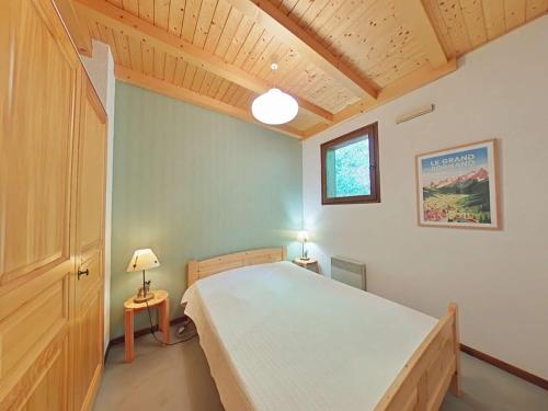 une chambre avec un grand lit dans une pièce dans l'établissement Appt 3 pièces, 7 pers, cheminée, garage, proche pistes - FR-1-241-50, au Grand-Bornand