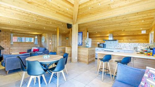 une cuisine et une salle à manger avec une table et des chaises dans l'établissement Chalet Flocon - Pra-Loup - Familial & Nature, à Uvernet