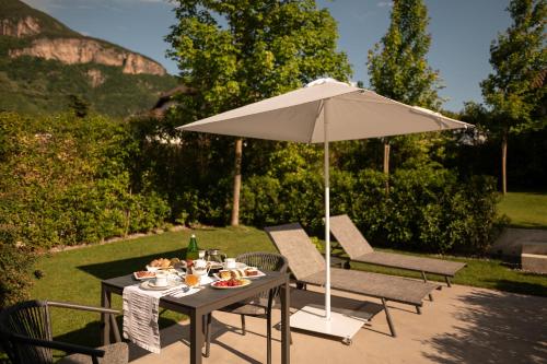 a table with an umbrella with a plate of food on it at Agriturismo Insolito in Terlano