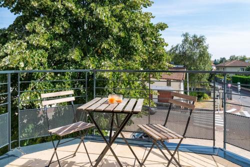 a wooden table and two chairs on a balcony at Le Loft de Genas - l'Atelier et la Villa in Genas