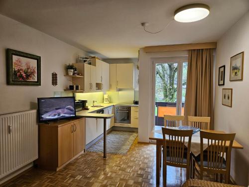 a kitchen with a table with a television and a dining room at Appartementanlage Thermenblick SKI IN & SKI OUT in Bad Kleinkirchheim