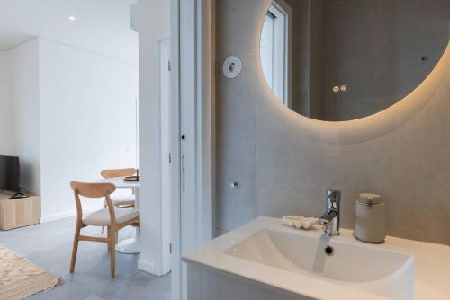 Un baño con un lavabo y un espejo en la pared. en 176 - Charming Riverview Apartment, en Oeiras