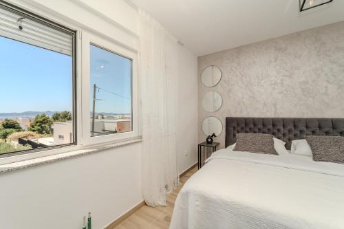 a bedroom with a bed and a large window at Apartment Anna - free private parking in Zadar