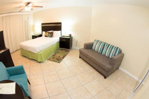 a bedroom with a bed and a couch and a chair at Holiday Inn Resort Grand Cayman by IHG in George Town