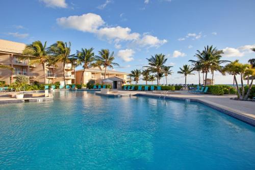 a large swimming pool with palm trees and condos at Holiday Inn Resort Grand Cayman by IHG in George Town