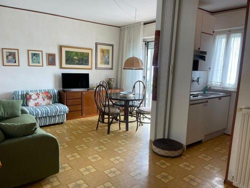 Una sala de estar con un sofá y una mesa y una cocina. en Villa Savoia& Villa Trieste, en Grado