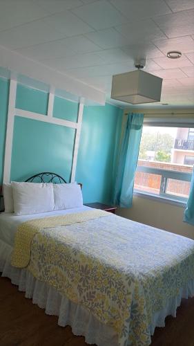 a bedroom with a bed with a blue wall at The Rex Motel At Niagara Falls in Niagara Falls